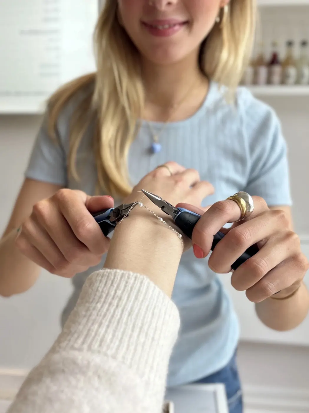 SMYKBARs personale lukker et færdigt armbånd om håndleddet på en gæst